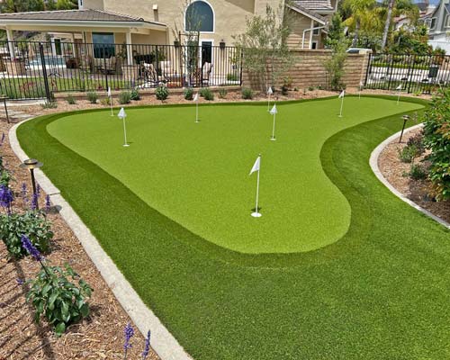 Residential artificial putting green with multiple practice holes and curved turf design