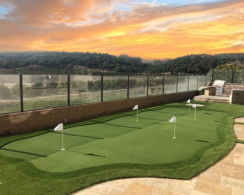 Residential artificial putting green in backyard patio with multiple practice holes