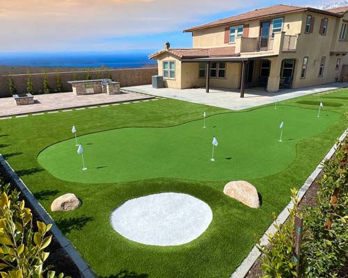 Residential putting green installation featuring bunker and practice layout
