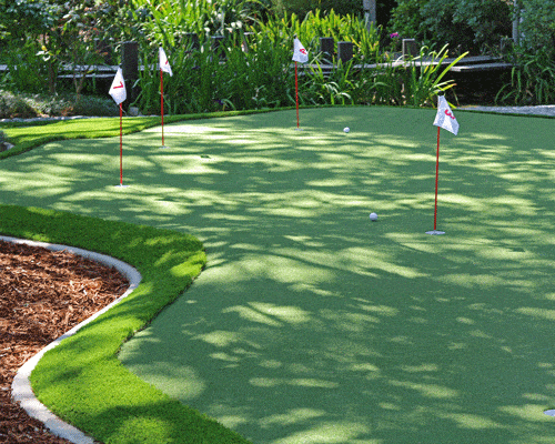 Putting green turf detail showing multiple holes and smooth practice surface