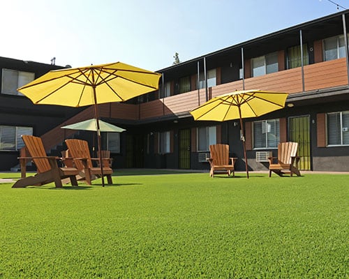 Artificial grass lawn used as shared outdoor seating area in apartment courtyard