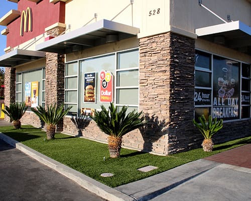 Artificial grass landscape installation along restaurant exterior and sidewalk