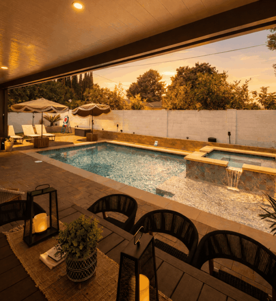 outdoor-living-space-backyard-renovation-pool-jurupa-valley-ca Backyard pool and spa with waterfall feature, poolside seating, and sunset outdoor entertaining space.