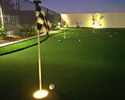Backyard putting green with nighttime lighting for evening practice